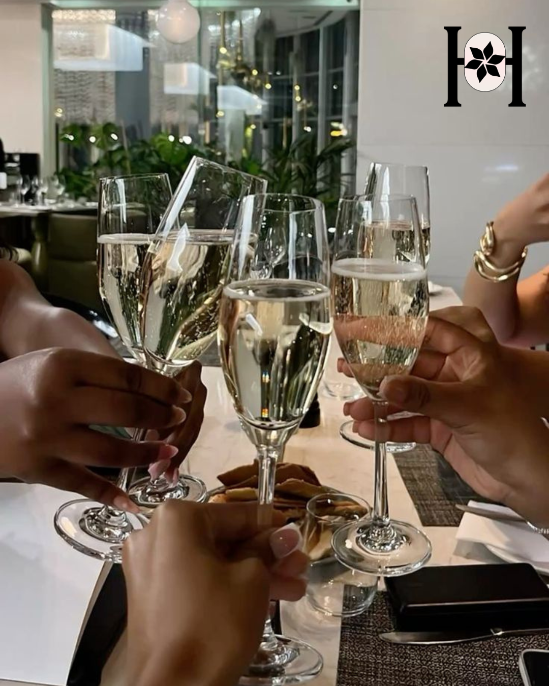 People toasting with champagne glasses at a dining table.